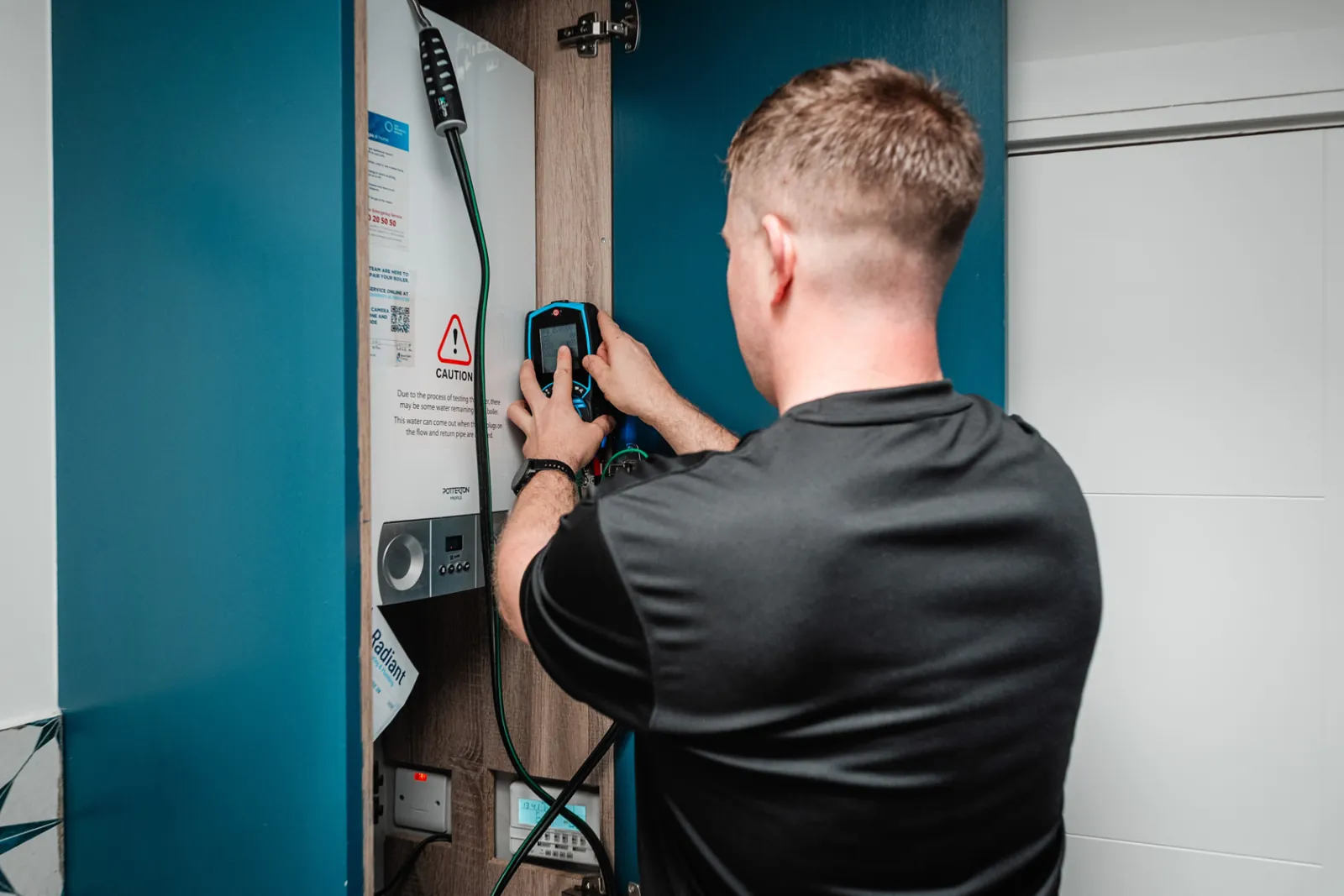 Boiler being tested with a flue gas analyser inside a hall press