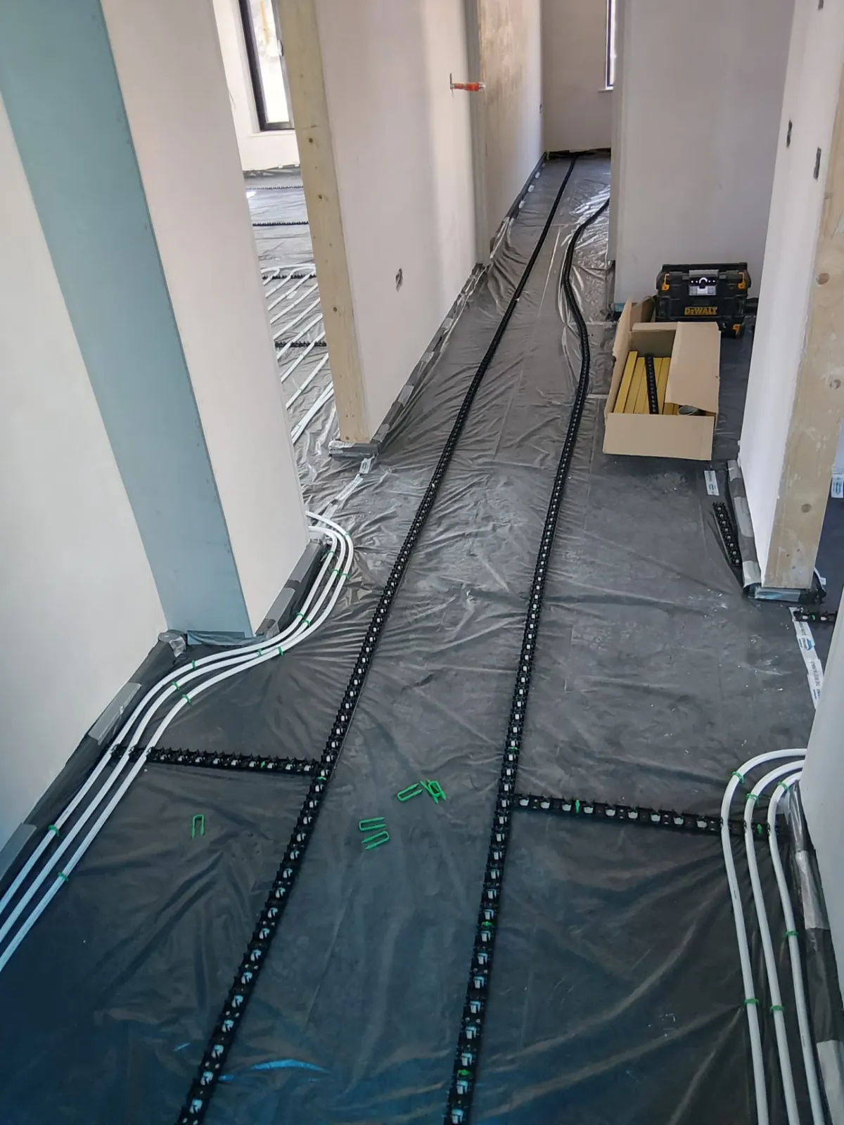 Underfloor heating pipe loops laid out in a hallway